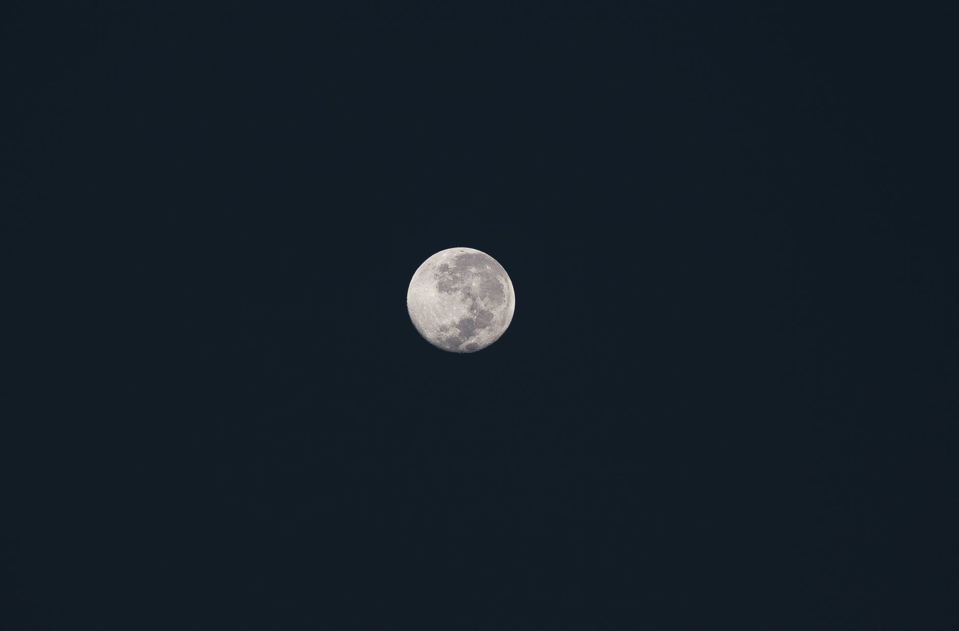 a full moon on a dark sky
